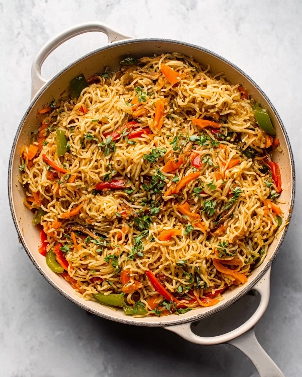 A white frying pan filled with cooked noodles mixed with chopped vegetables, including green, orange, and red bell peppers, scattered evenly throughout. The noodles are golden brown and slightly glossy, with small bits of greens and herbs sprinkled on top. The pan is placed on a white marbled surface, and there is no utensil or woman's hand in the image. The lighting is bright and natural, highlighting the textures of the noodles and vegetables clearly. Photo taken with an iphone --ar 4:5 --v 7